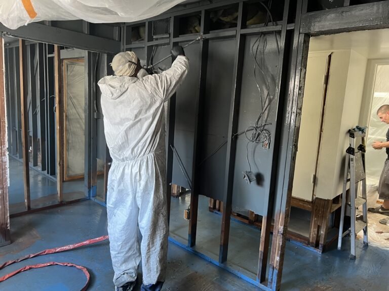 Applying Odor Encapsulator to wall studs.